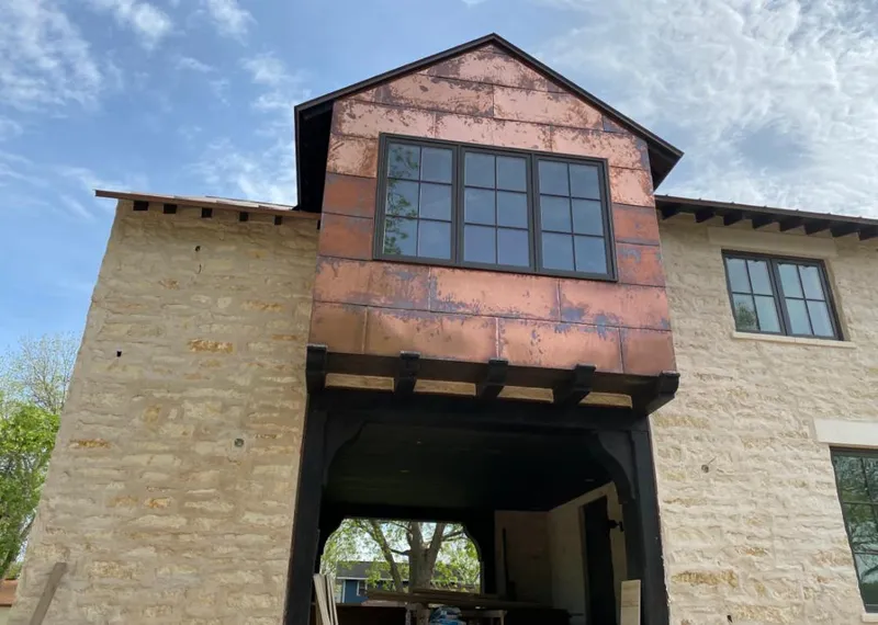 Copper metal panel facade on a stone building for Roof Repair in Crafton