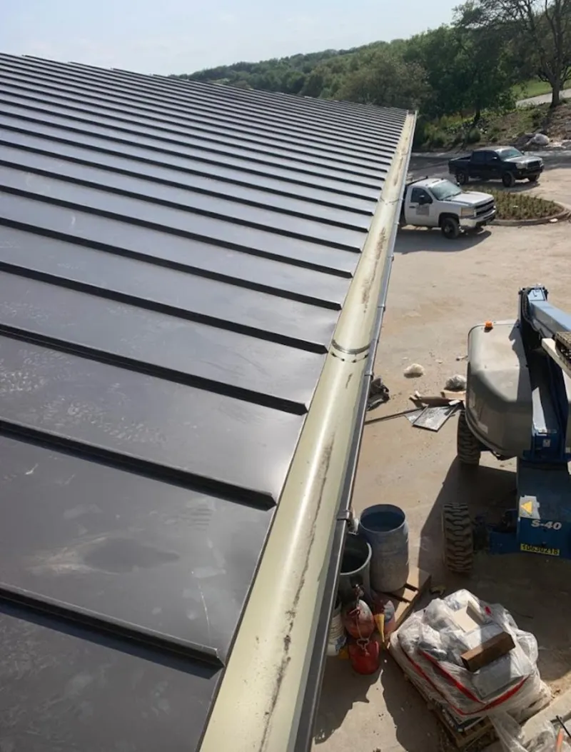 Standing seam panel and gutter detail on a metal roofing jobsite in Crafton